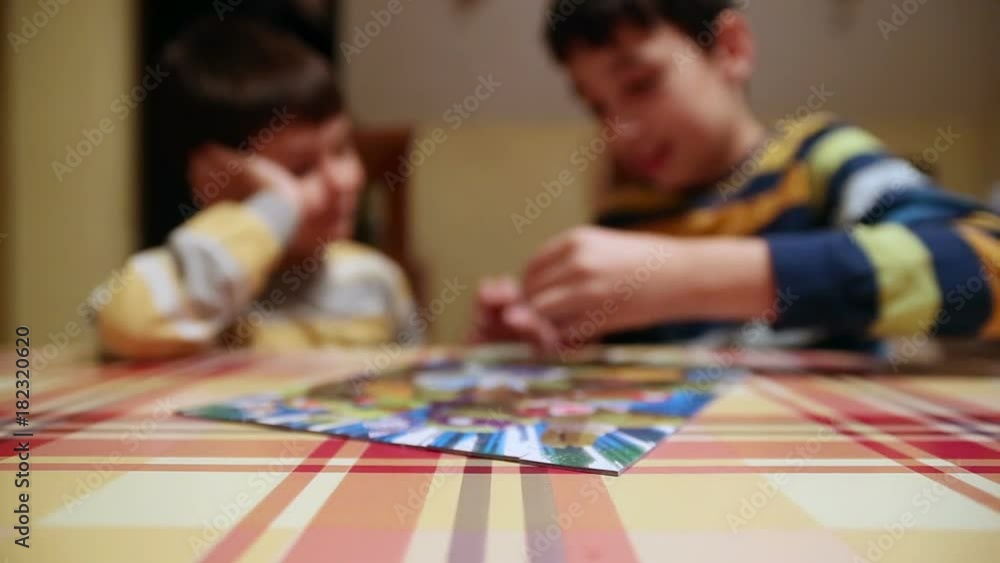 Two little brothers resolving last puzzle piece. Two little brothers resolving last puzzle piece.