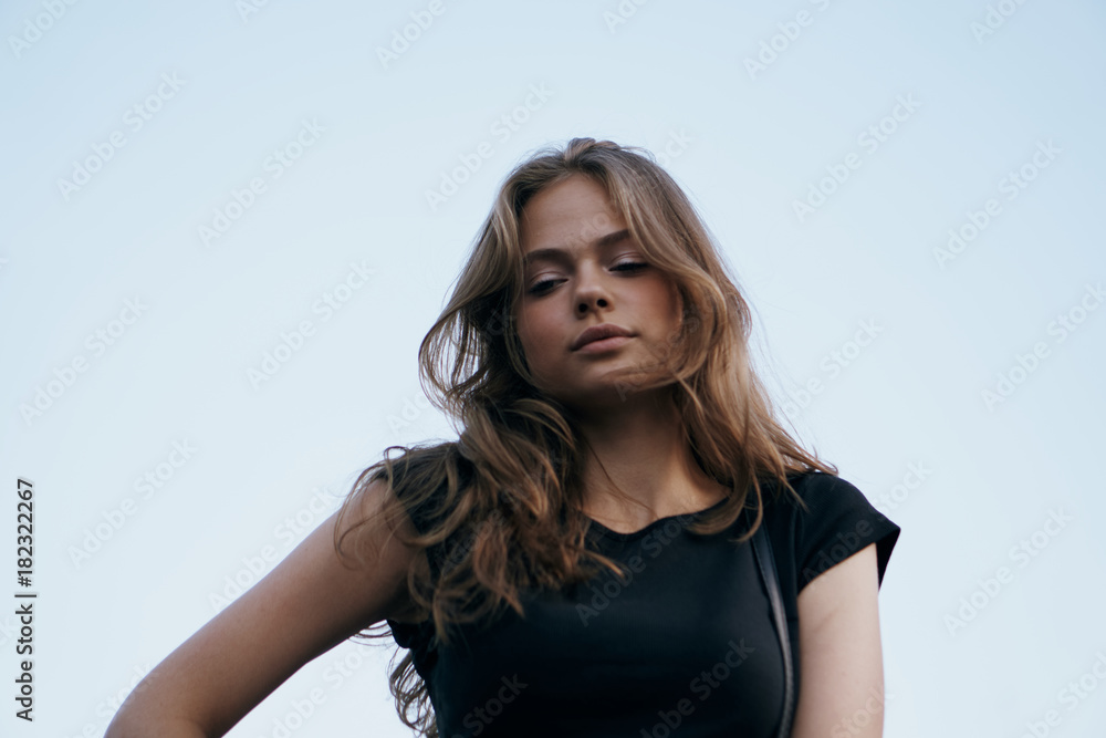 Young beautiful woman is walking outdoors in the city, sky Young beautiful woman is walking outdoors in the city, sky
