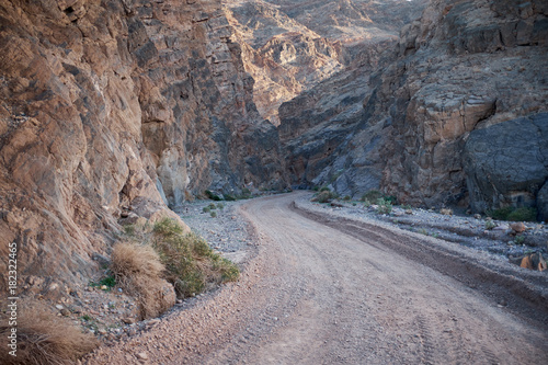 Dirt road through rocky canyon, Death Valley, USA © Colby