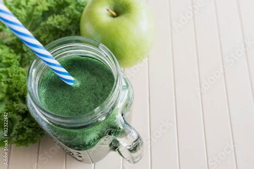 Green smoothie with apple on the wooden background