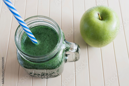 Green smoothie with apple on the wooden background