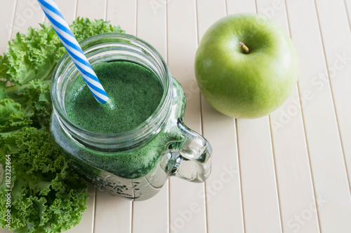 Green smoothie with apple on the wooden background