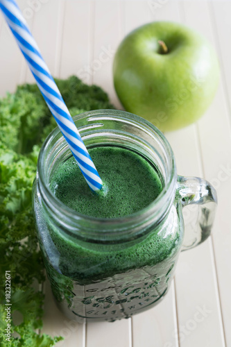 Green smoothie with apple on the wooden background