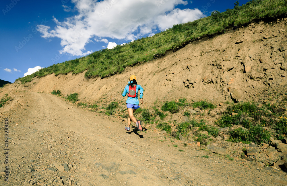 young fitness woman trail runner running on high altitude trail