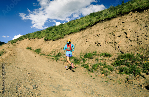 young fitness woman trail runner running on high altitude trail