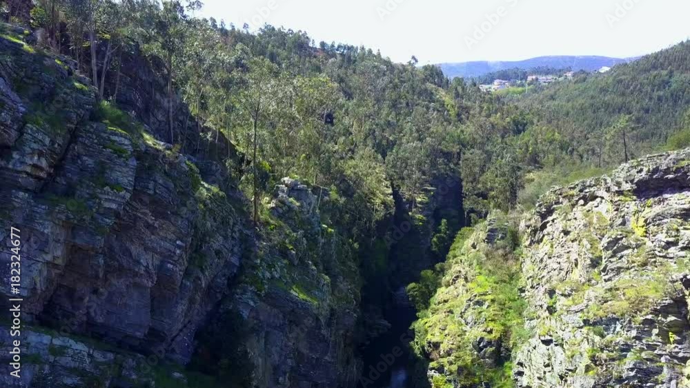 Slow and smooth aerial exploring of a small cottage near a waterfall in a rocky canyon in Porto on a sunny day, Slow and smooth aerial exploring of a small cottage near a waterfall in a rocky canyon in Porto on a sunny day,