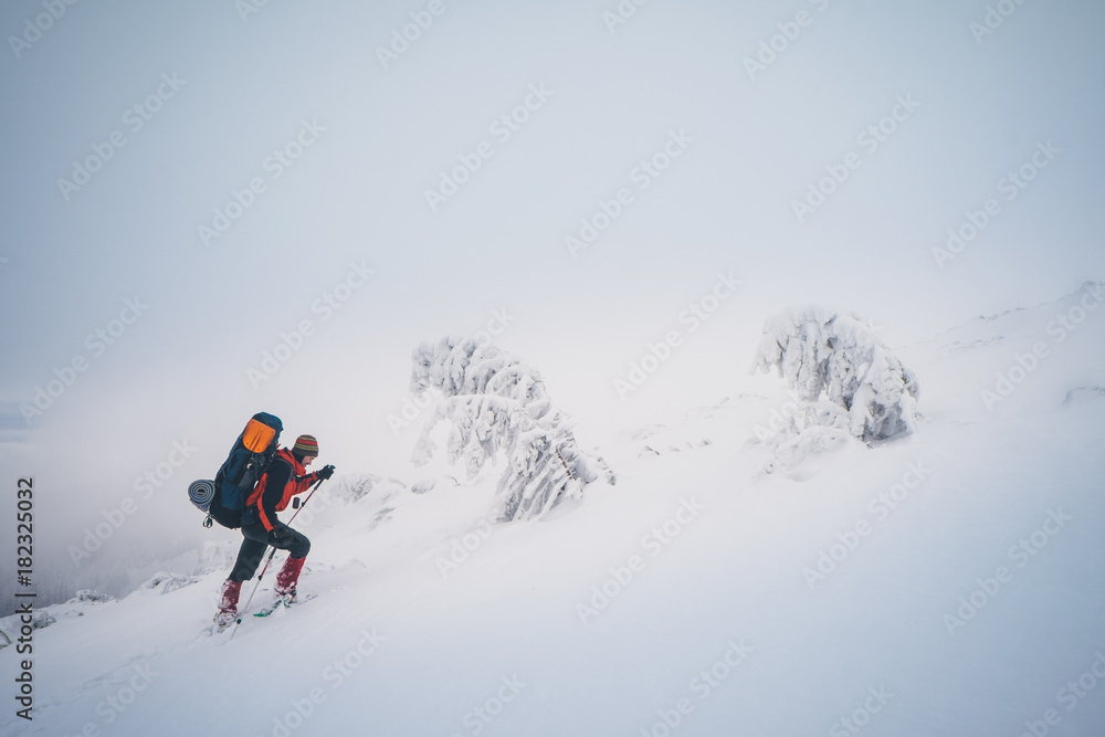 Extreme hiking with backpack in winter mountain landscape
