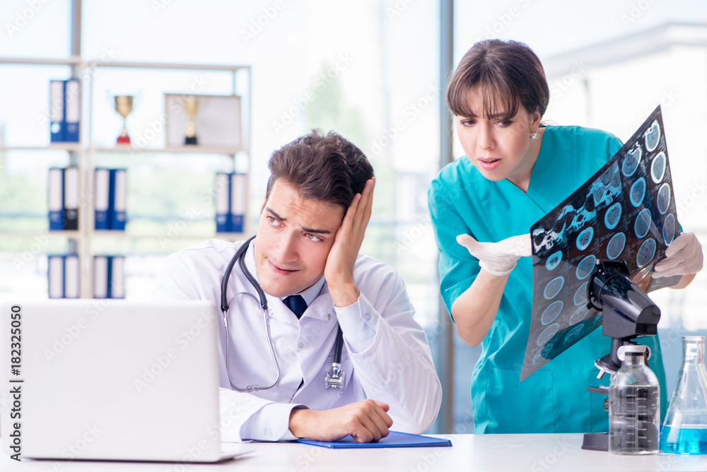 Obraz premium Two doctors discussing x-ray MRI image in hospital