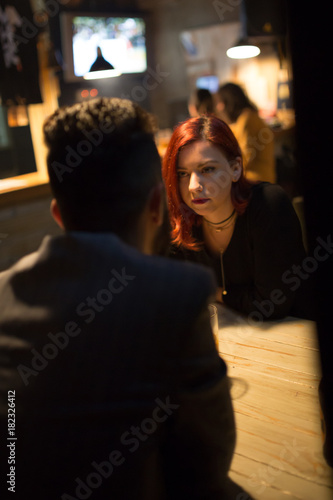 Girl in a pub, listening his friend talking