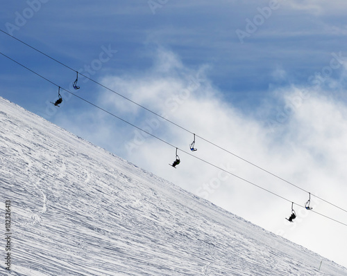 Snowy off-piste ski slope and chair-lift in fog