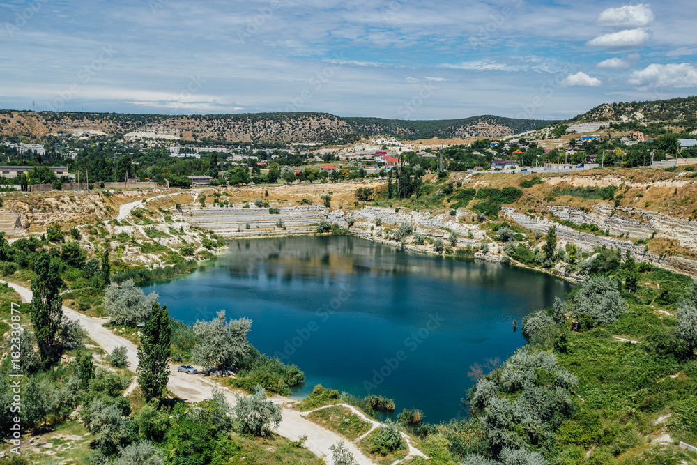 Flooded quarry in Crimea. Blue pond on the place of former whiter limestone mine