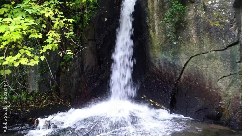 Waterfall in a river between rocks and trees 