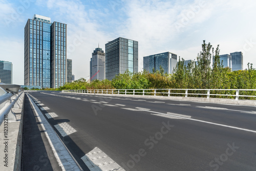 road through the bridge with city skyline background. © hallojulie
