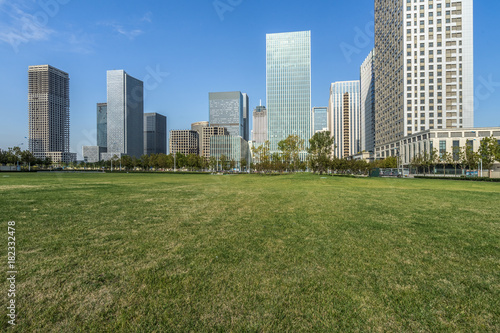cityscape and skyline of Tianjin from meadow in park
