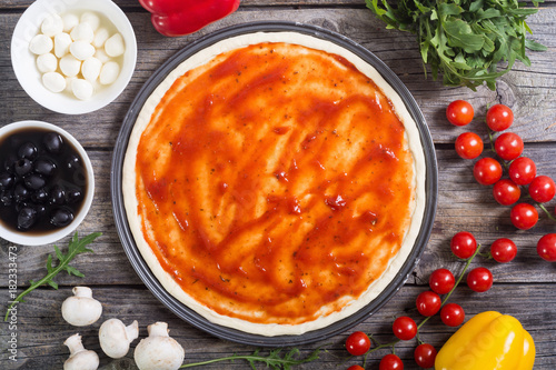 Preparation italian pizza with olives , mozzarella , tomatoes and mushrooms photo