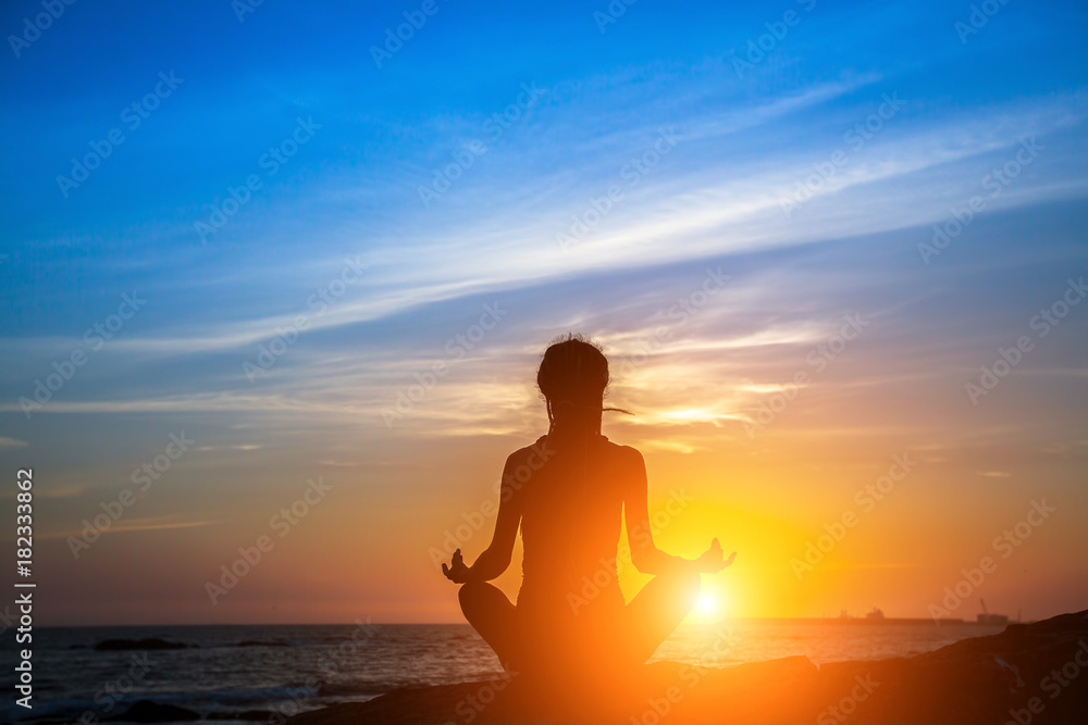 Meditation yoga woman silhouette on the Sea during amazing sunset. Meditation yoga woman silhouette on the Sea during amazing sunset.