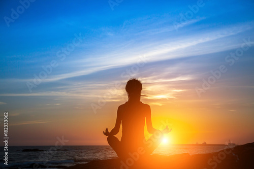 Meditation yoga woman silhouette on the Sea during amazing sunset. © De Visu