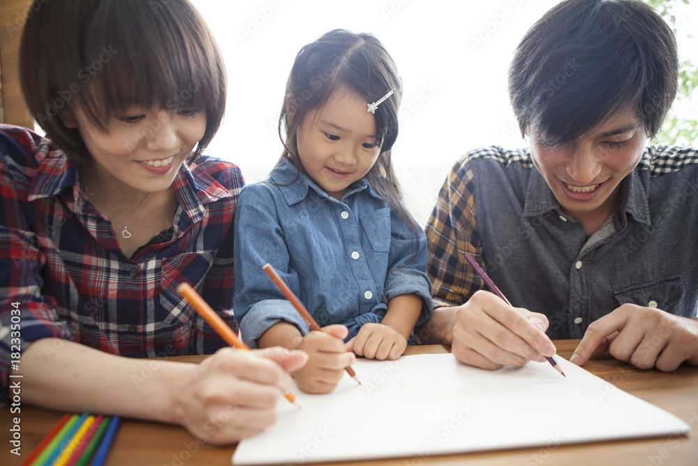Dad, mommy and daughter are painting with colored pencils. Dad, mommy and daughter are painting with colored pencils.