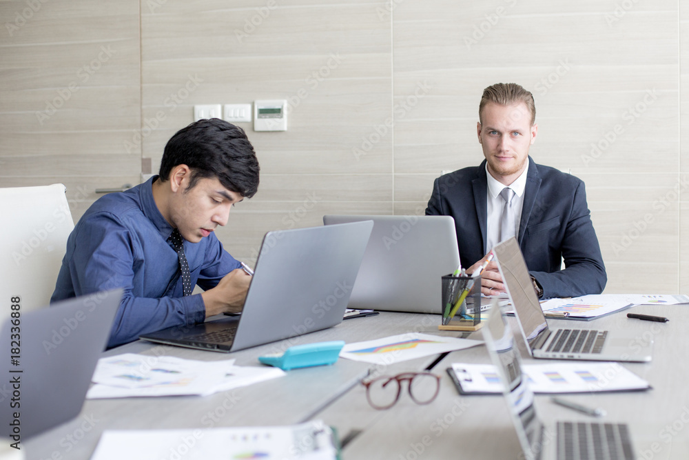Business people working at meeting room together. Business people working at meeting room together.