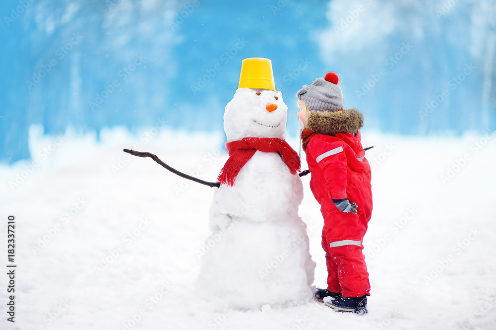 Little boy tell snowman about his secrets or gifts for Christmas