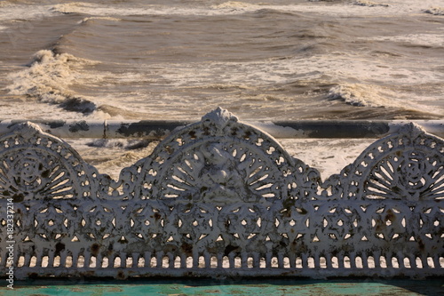 Cast iron park benches on a windy seashore