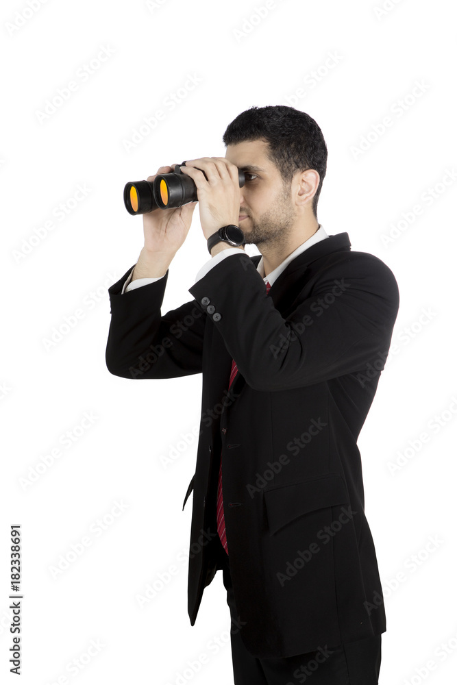 Young businessman using a binocular on studio Young businessman using a binocular on studio