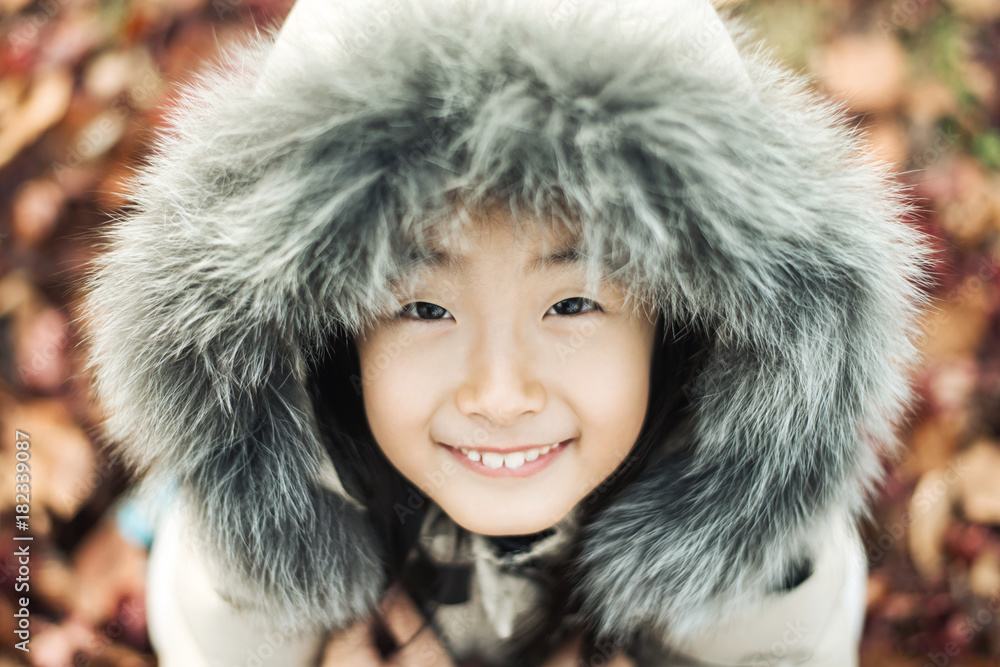 smiling asian Little girl in a winter fur hat smiling asian Little girl in a winter fur hat