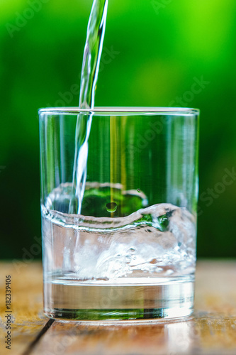 A glass of water on green background