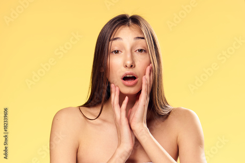 Young beautiful woman on a yellow background, portrait, emotions