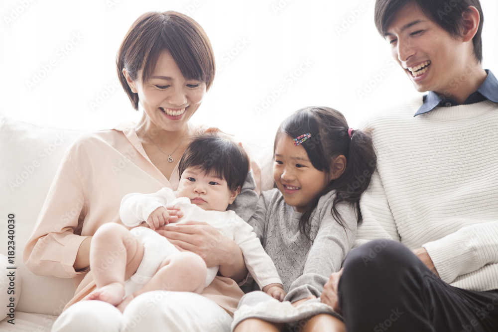 Parents, daughter and baby are sitting on the sofa and talking. Parents, daughter and baby are sitting on the sofa and talking.