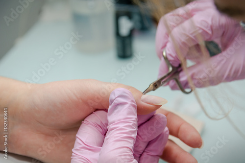 Putting varnish on nails. Processing of nails in beauty shop.