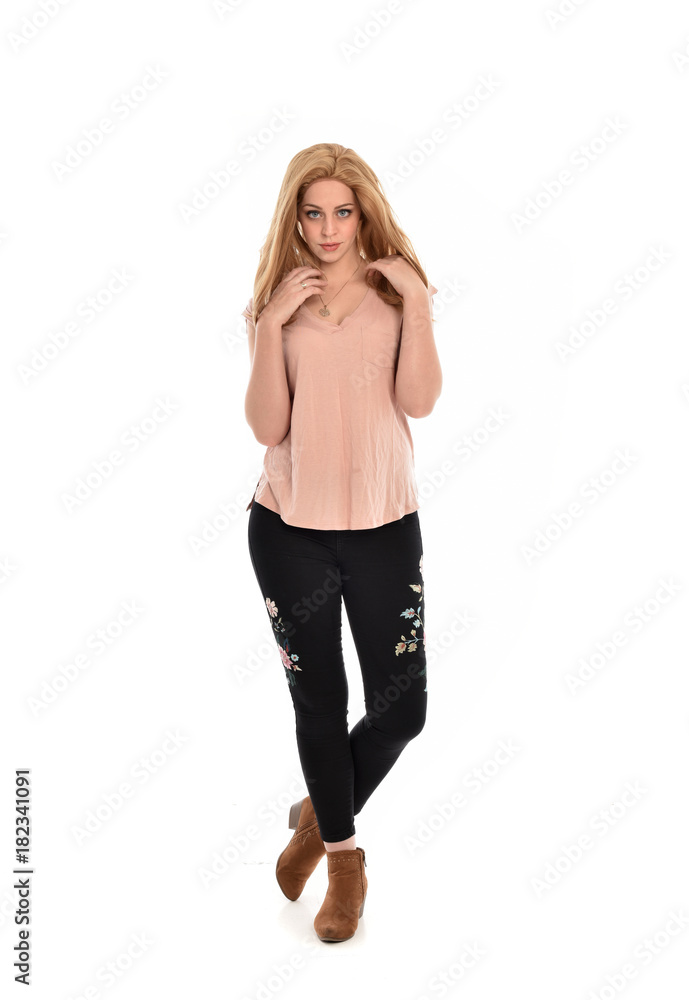 Fototapeta premium full length portrait of a girl wearing pink shirt and black floral pants. standing pose, isolated on white background.