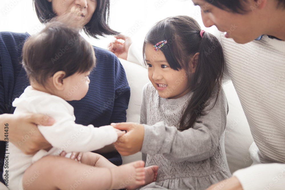 Parents, daughter and baby are sitting on the sofa and talking. Parents, daughter and baby are sitting on the sofa and talking.