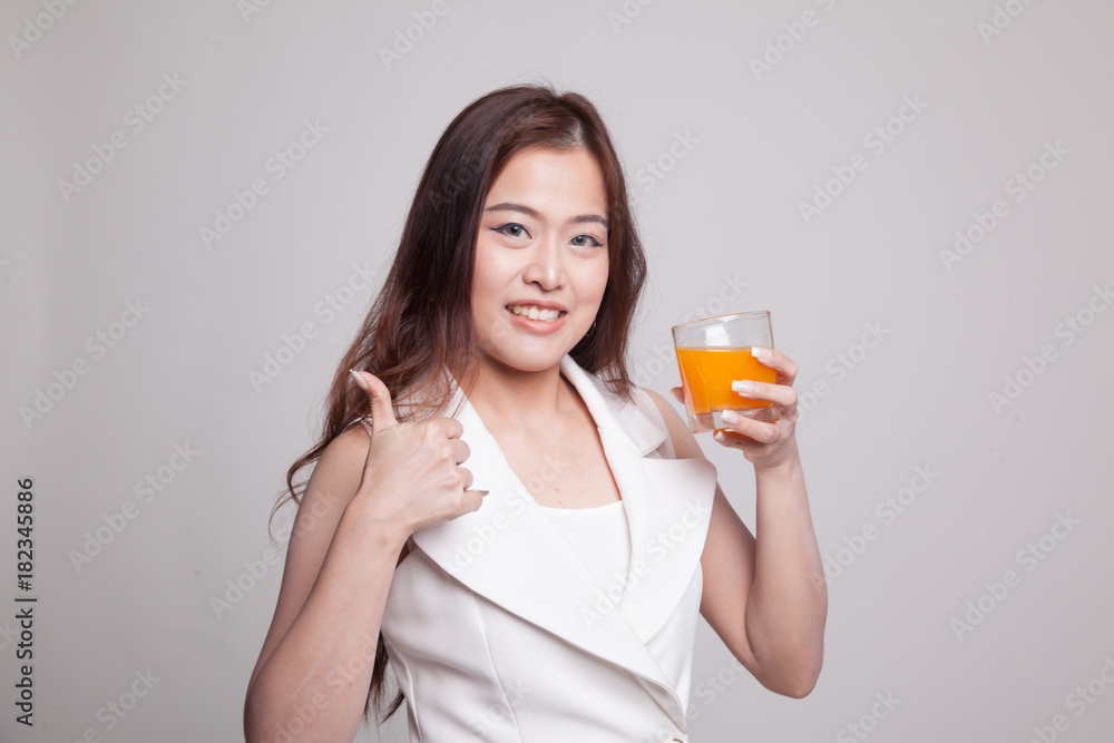 Young Asian woman thumbs up drink orange juice. Young Asian woman thumbs up drink orange juice.