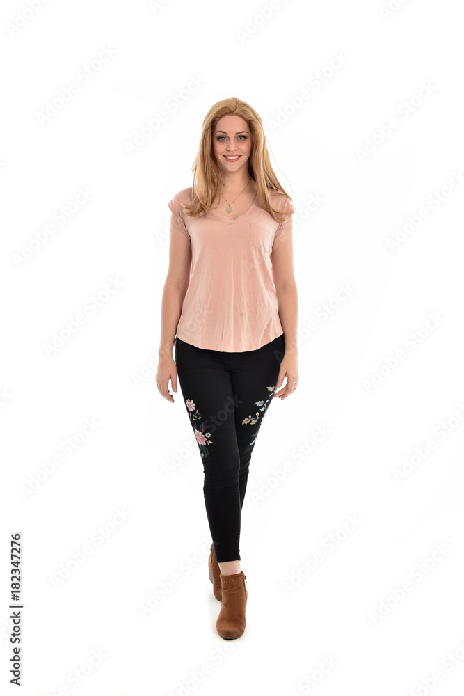 Fototapeta premium full length portrait of a girl wearing pink shirt and black floral pants. standing pose, isolated on white background.