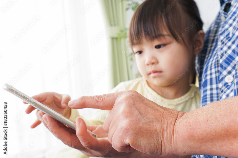 おばあちゃんとスマホを使う子供 おばあちゃんとスマホを使う子供