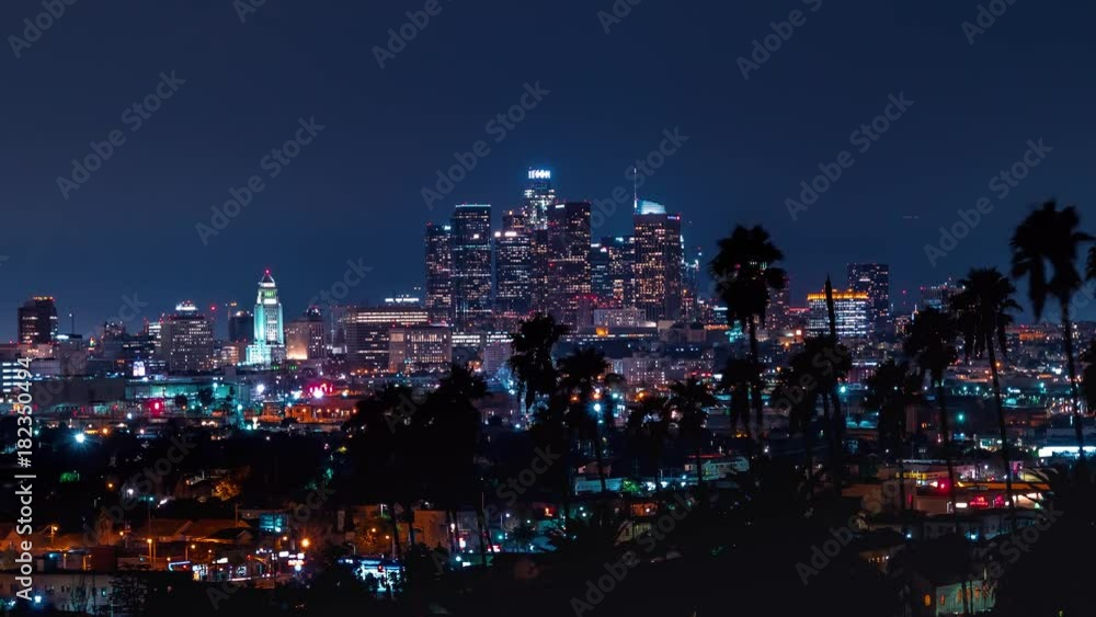 Time-lapse of Downtown Los Angeles cityscape with palm trees in the foreground Time-lapse of Downtown Los Angeles cityscape with palm trees in the foreground