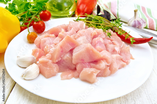 Chicken breast raw sliced in plate on light board