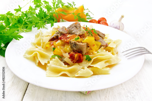 Farfalle with turkey and vegetables in sauce on board