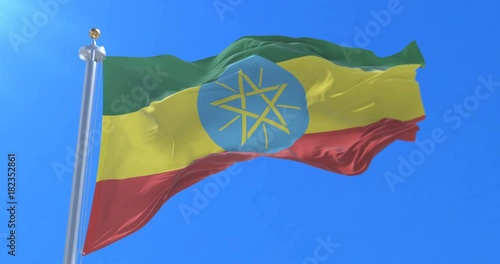 Flag of Ethiopia waving at wind with blue sky in slow, loop photo