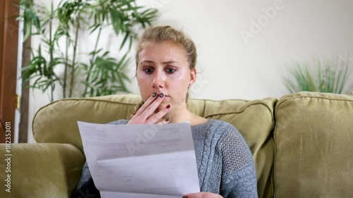 Caucasian Twenties female in shock over bill in the mail ALT