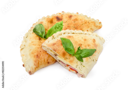 One whole and half of cooked calzone with basil twigs