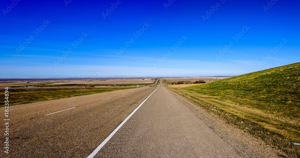 Beautiful panorama of an asphalt road, a highway with wide fields