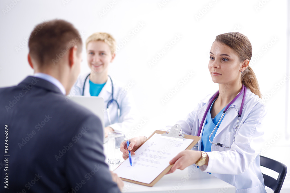 Women doctor and patient sitting at the desk in hospital. Women doctor Women doctor and patient sitting at the desk in hospital. Women doctor