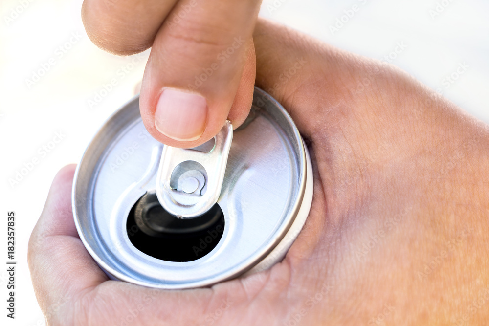 Fototapeta premium A hand opening a canned beverage.