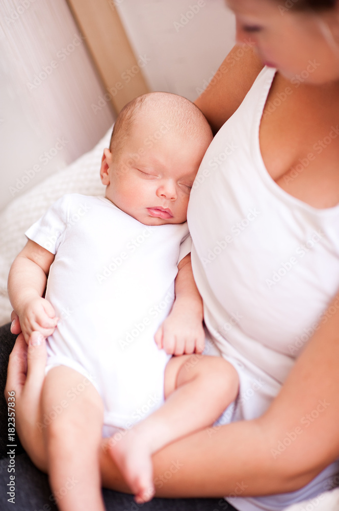 Happy woman holding sleepy baby on hands closeup. Motherhood. Maternity. 20s. Happy woman holding sleepy baby on hands closeup. Motherhood. Maternity. 20s.