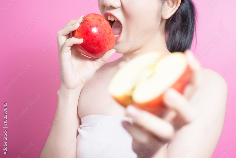 Asian woman with apple concept. She smiling and holding apple. Beauty face and natural makeup. Isolated over pink background. Asian woman with apple concept. She smiling and holding apple. Beauty face and natural makeup. Isolated over pink background.