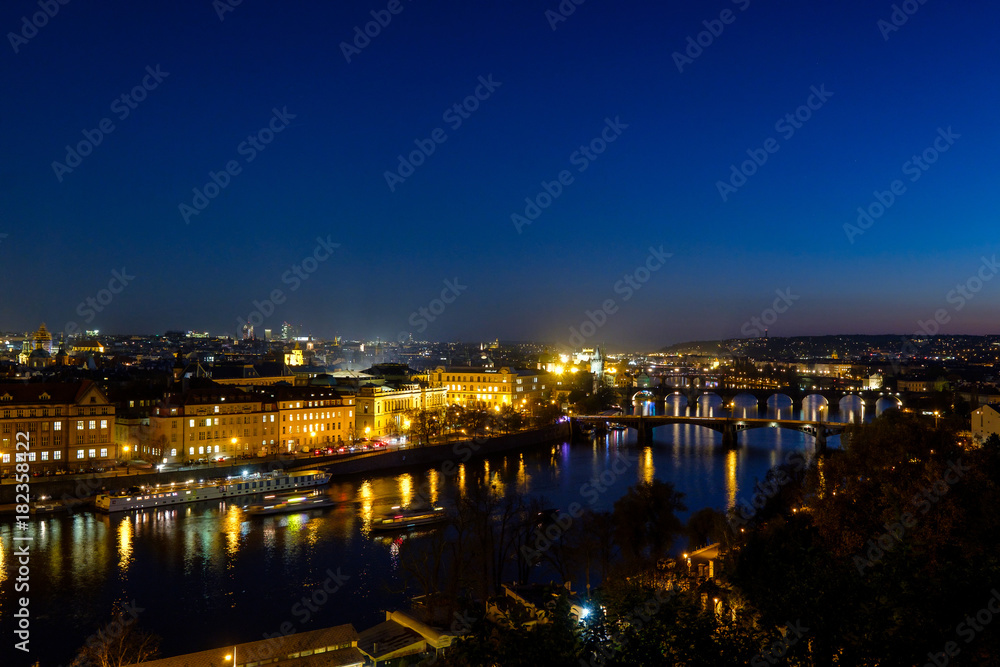 Panorama of the old part of Prague from the Letna park at dusk. Beautiful view on the bridges over the river Vltava at sunset. Old Town architecture, Czech Republic.