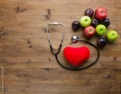 Diet concept with medical stethoscope heart toy and fresh fruits