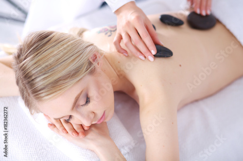Young woman lying on a massage table,relaxing with eyes closed. Woman. Spa salon © lenets_tan